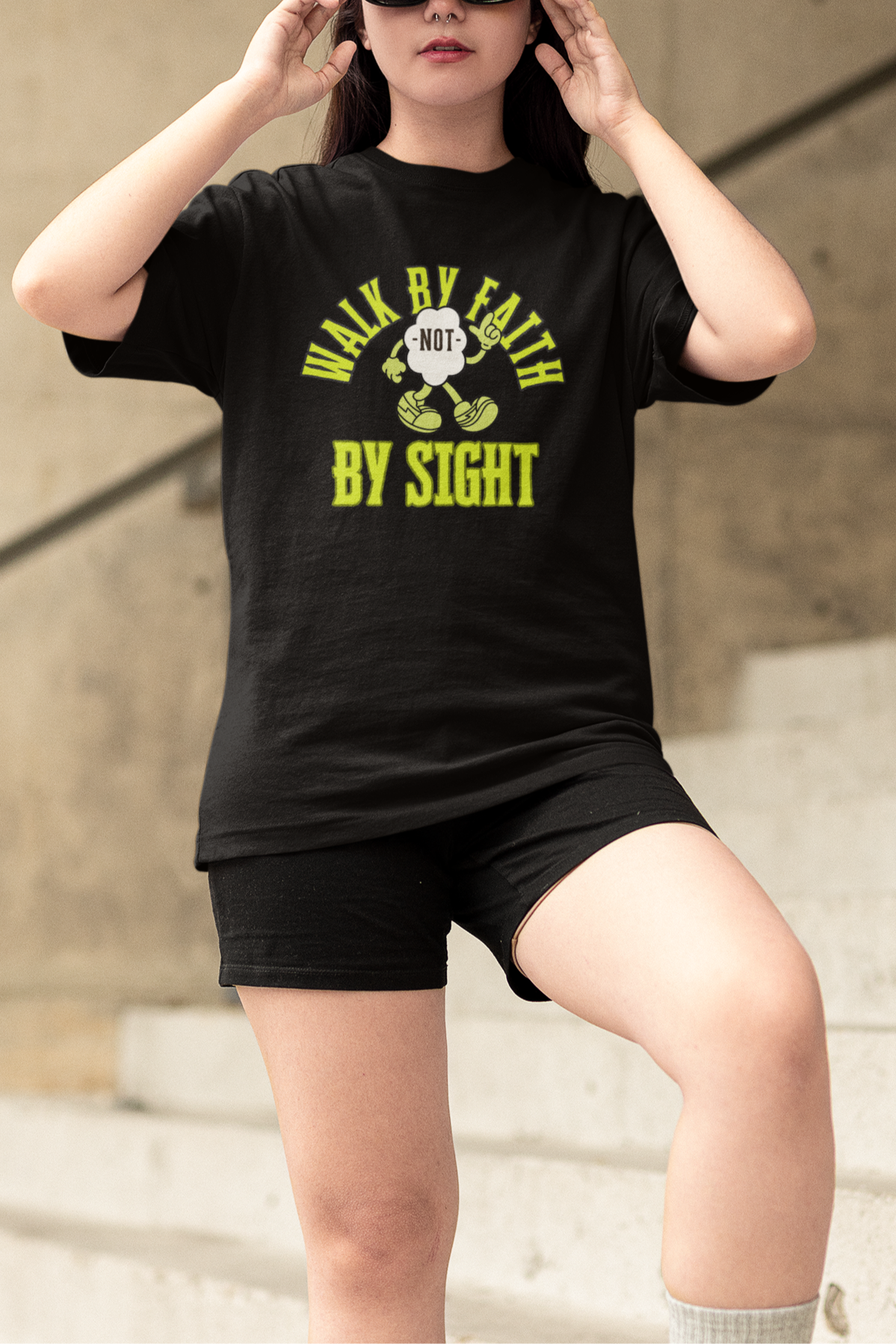 Person wearing a black t-shirt with text and graphics, standing outdoors.